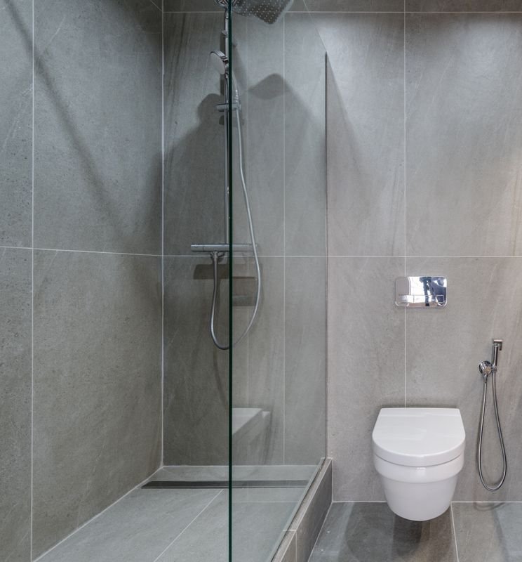 Modern walk-in shower with frameless glass and stone tile